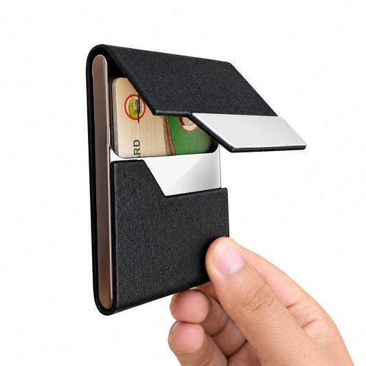 Hand holding a partially open plain black leather and stainless steel business card holder showing cards inside.