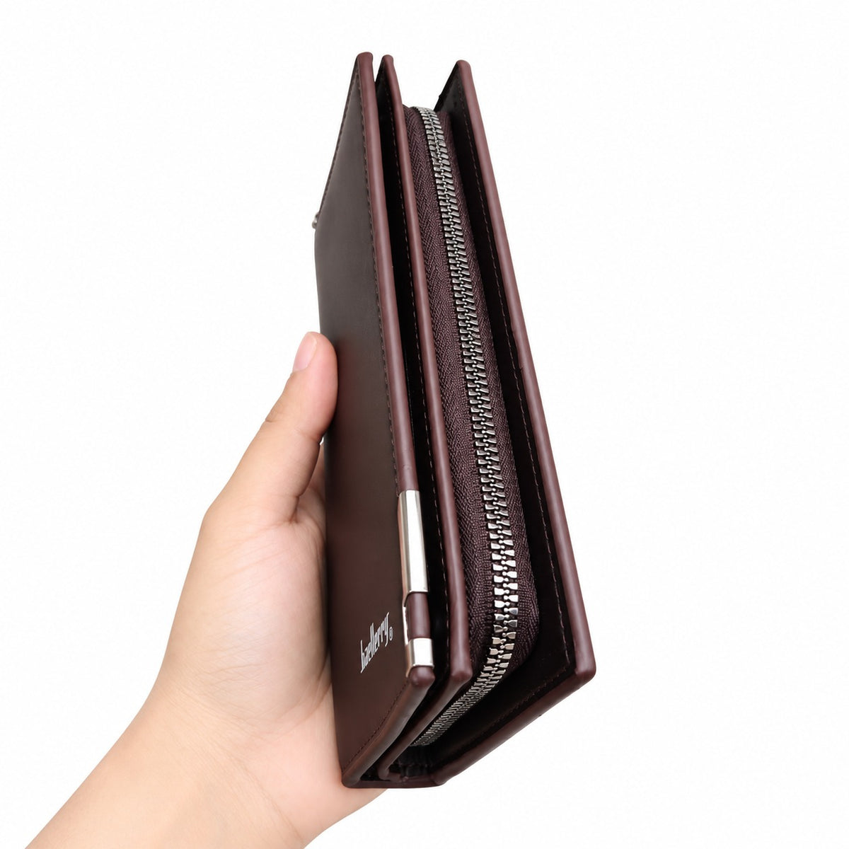 A hand holding a slim, dark brown leather wallet with a silver zipper and a small silver logo, shown against a plain white background.