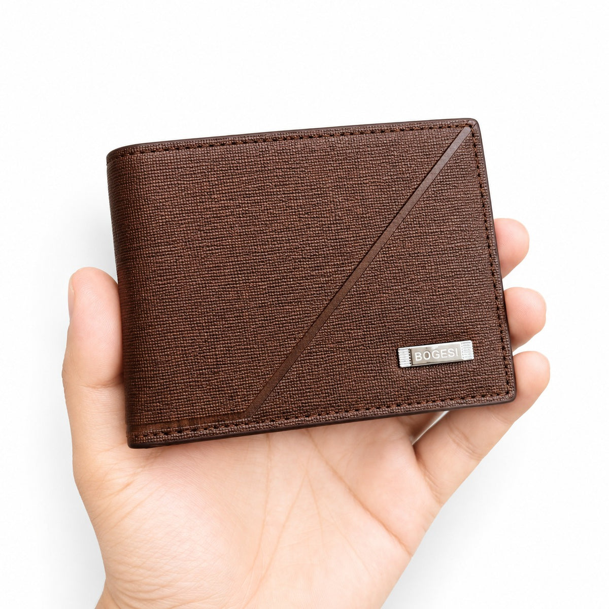 A brown textured leather bi-fold wallet held in a hand against a clean white background. The wallet features a diagonal stitched accent and a small silver-tone metal brand plaque on the lower right corner that reads 'BICENTO'.