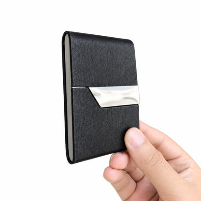 Front view of a closed, unbranded black textured leather slim wallet featuring a sleek silver stainless steel flap.